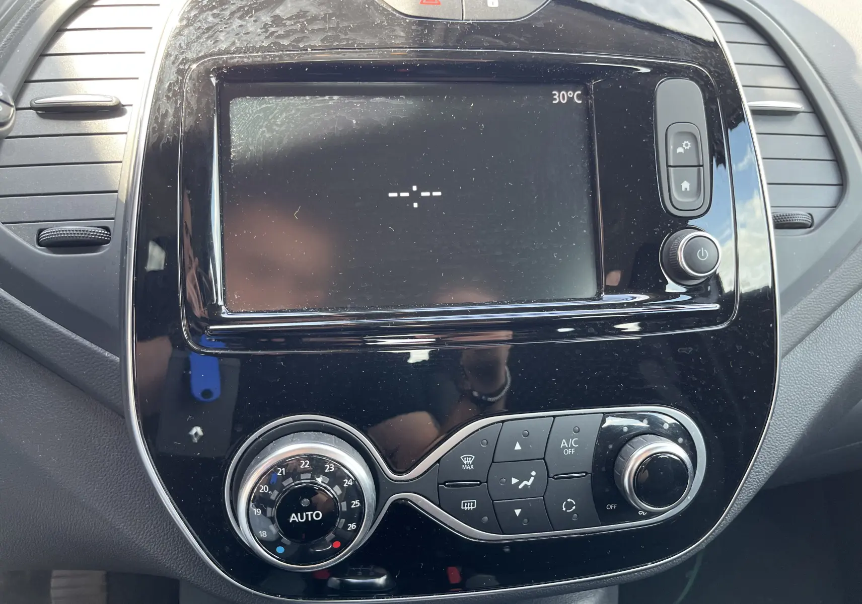 Tableau de bord noir du Renault Captur 2019 avec écran tactile et commandes climatisation en gros plan.