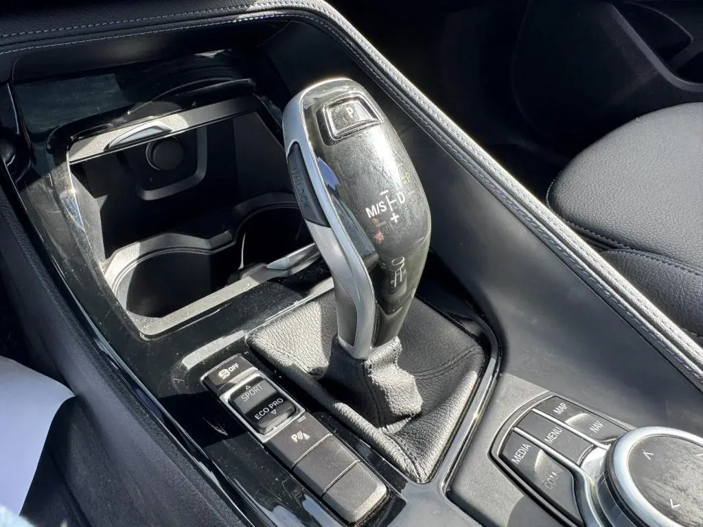 Le levier de vitesses automatique noir et argenté de la BMW X2 M Sport 2021, avec commandes de mode de conduite visibles.
