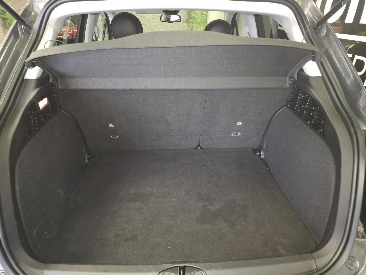 Coffre ouvert vu de l'arrière d'une Fiat 500X 2024 gris, montrant l'espace de chargement et la plage arrière.