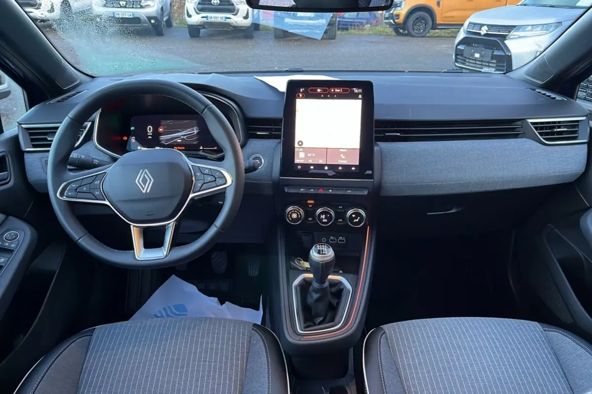 Intérieur de la Renault Clio V TCE 90 Techno Plus 2025, vue avant du tableau de bord avec écran tactile et boîte manuelle.