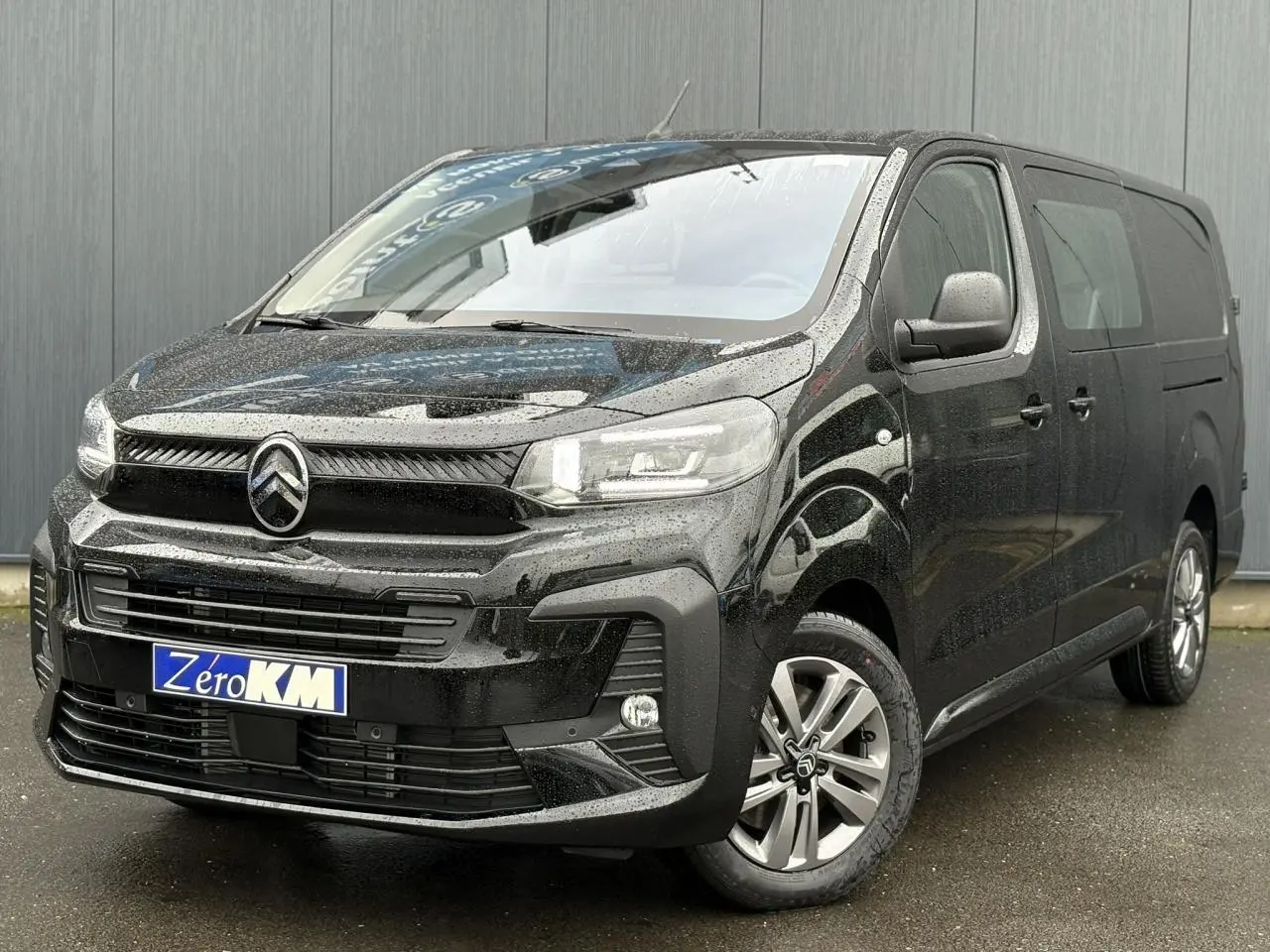 Vue 3/4 avant droite d'un Citroën Jumpy XL noir Perla avec jantes alliage 17'' grises sous la pluie.