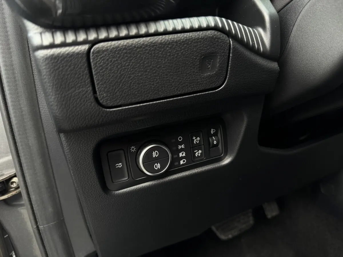 Gros plan sur les commandes d’éclairage noires situées à gauche du volant dans l’habitacle du Ford Ranger 2025.