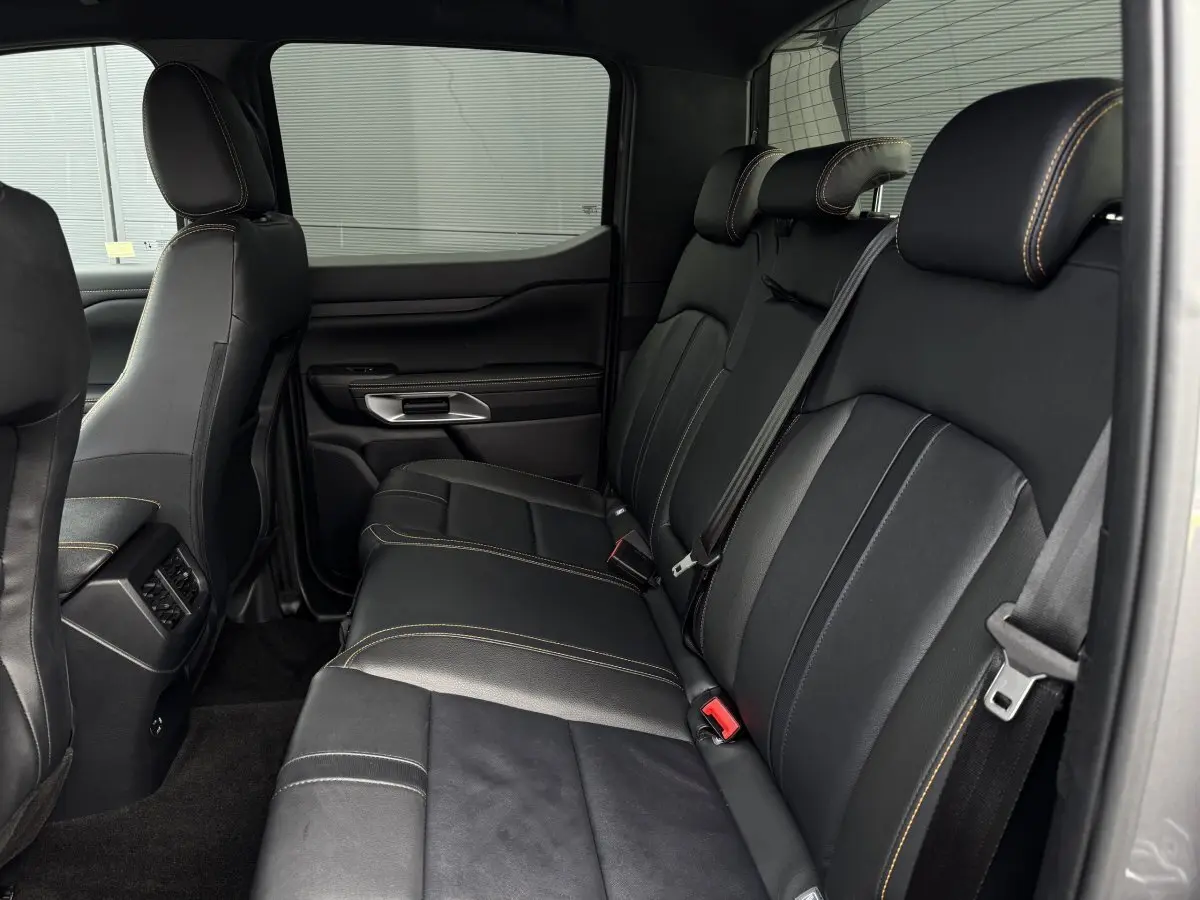 Vue latérale intérieure du siège arrière noir avec surpiqûres contrastantes du Ford Ranger Wildtrak 2025.