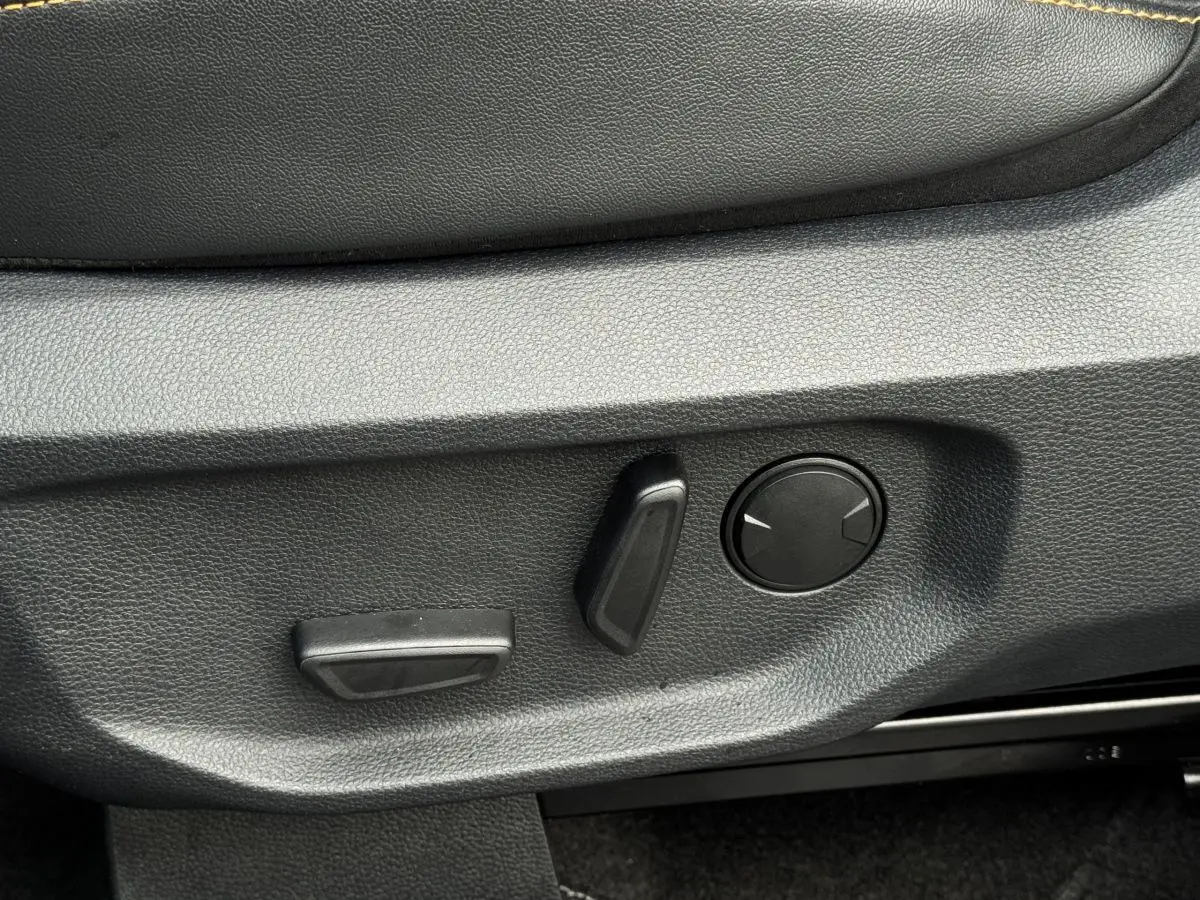 Gros plan sur les commandes de réglage électrique du siège côté conducteur du Ford Ranger 2025, intérieur noir.