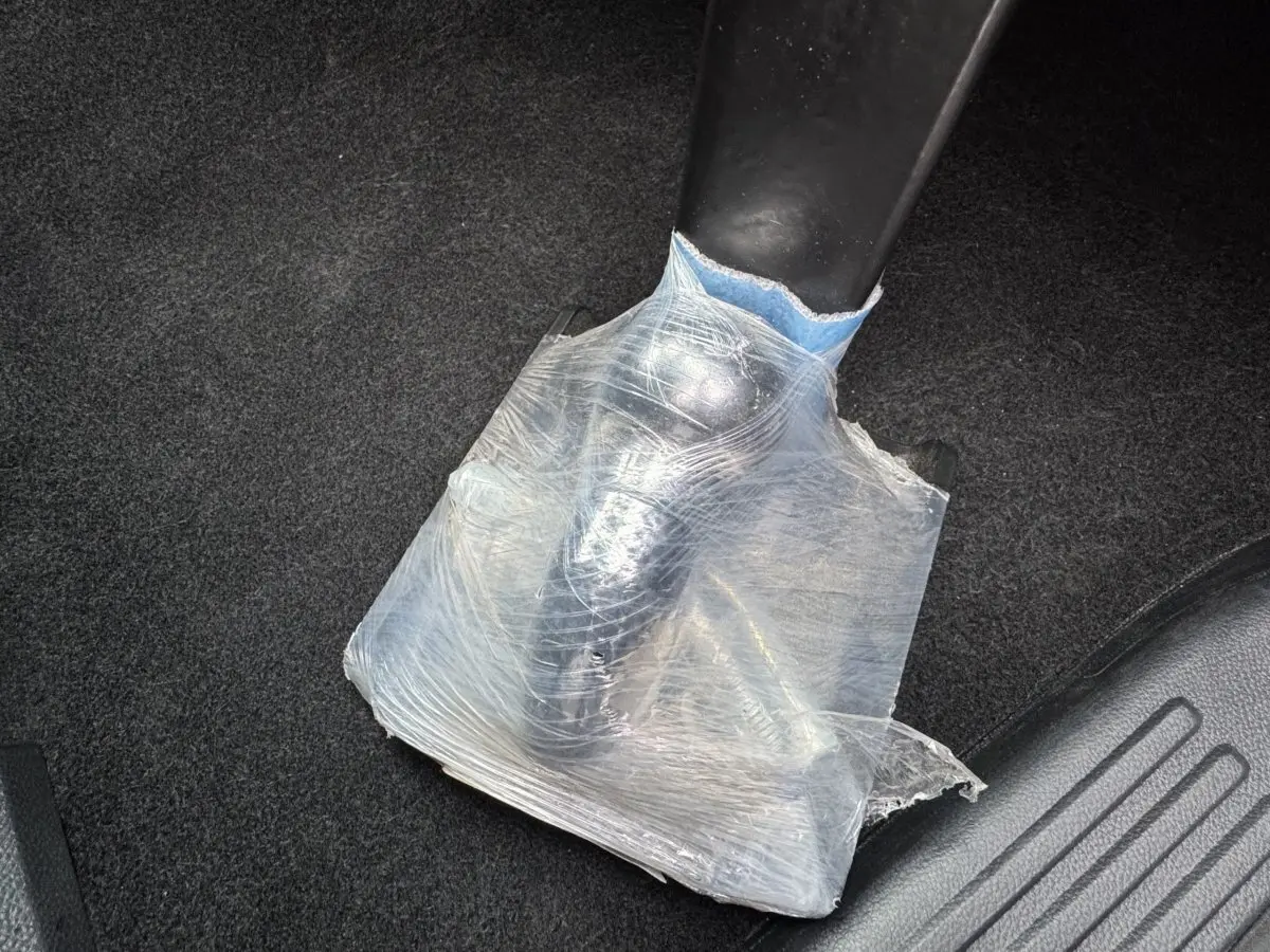 Détail du frein à main noir partiellement protégé par un film plastique transparent dans un Ford Ranger 2025.