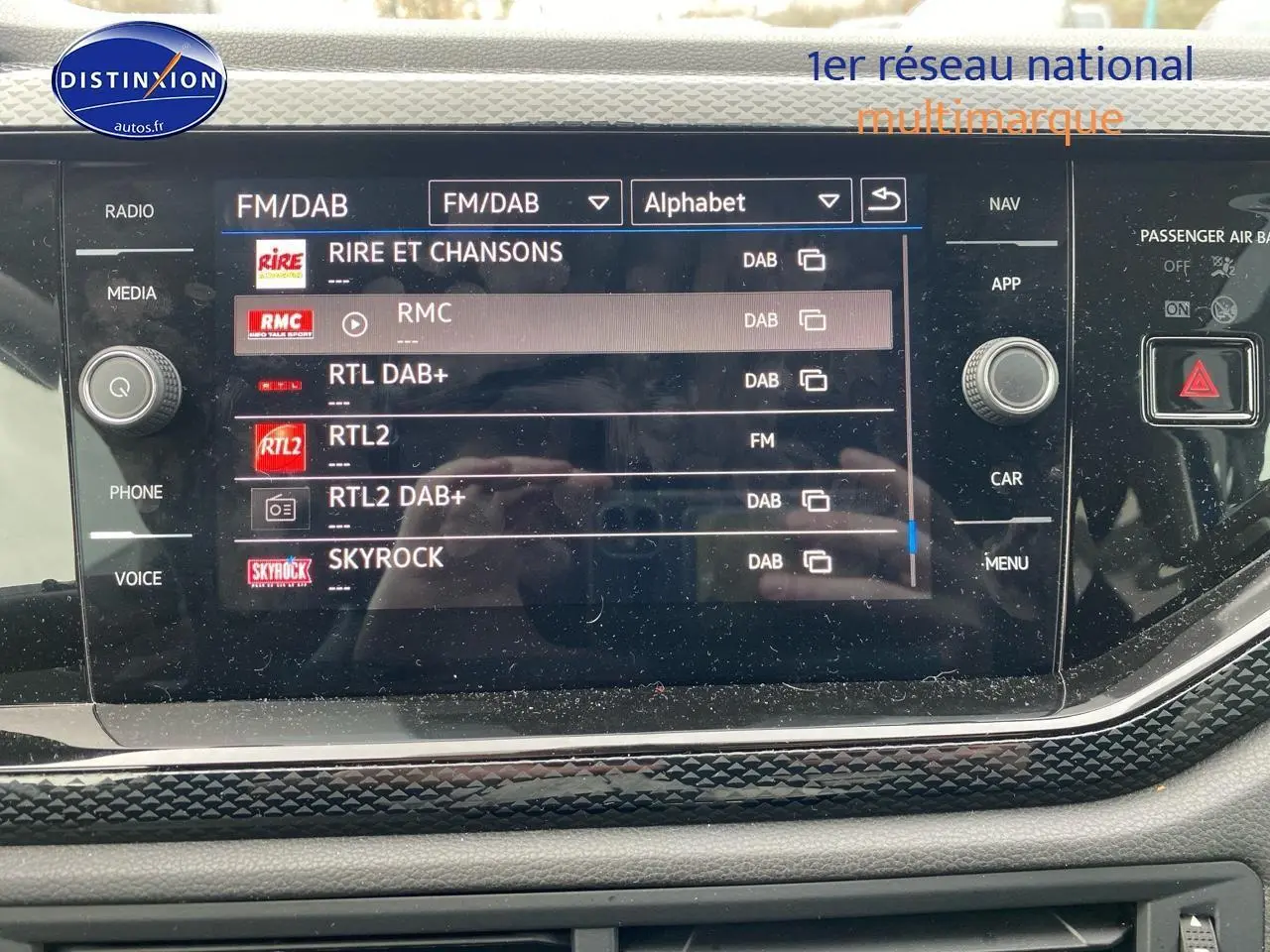 Écran tactile central de la Volkswagen Polo 2025 affichant les stations radio FM/DAB avec cadre noir et décor lava stone.
