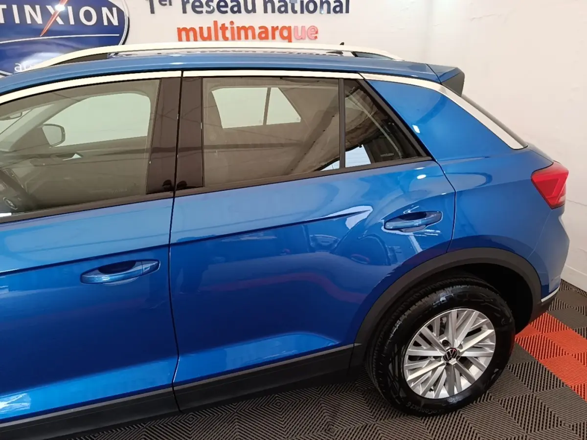 Vue latérale côté droit d'un Volkswagen T-Roc bleu 2020 avec toit blanc et jantes alliage.