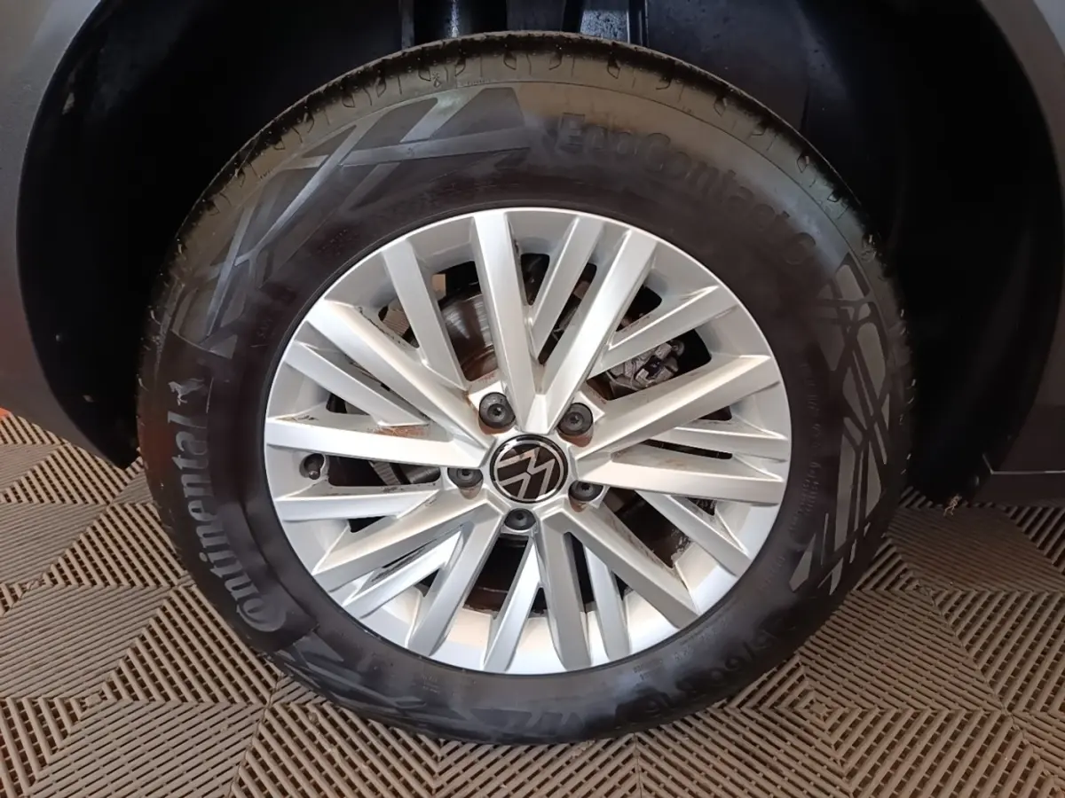 Gros plan sur la roue avant droite du Volkswagen T-Roc bleu, avec jante alliage argentée et pneu Continental.