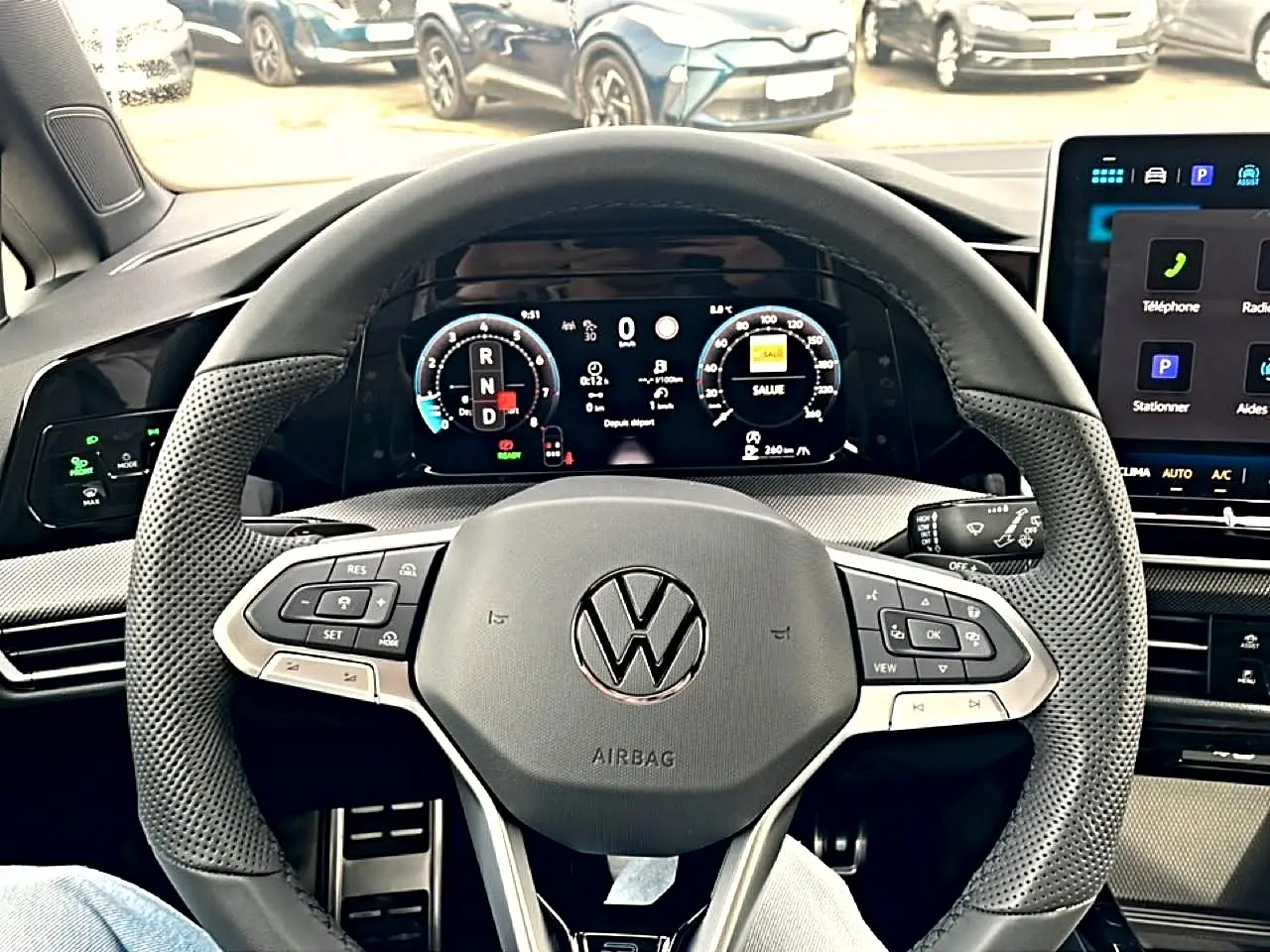 Vue intérieure centrée sur le volant cuir perforé noir et l'instrumentation numérique de la Volkswagen Golf 2026.