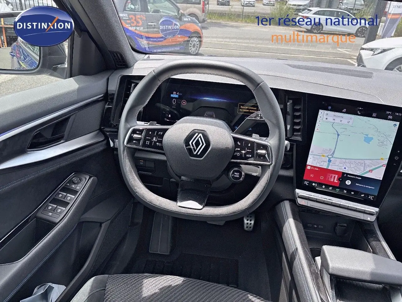 Vue intérieure du poste de conduite du Renault Austral E-Tech hybride 2022, avec volant multifonction et écran tactile central.