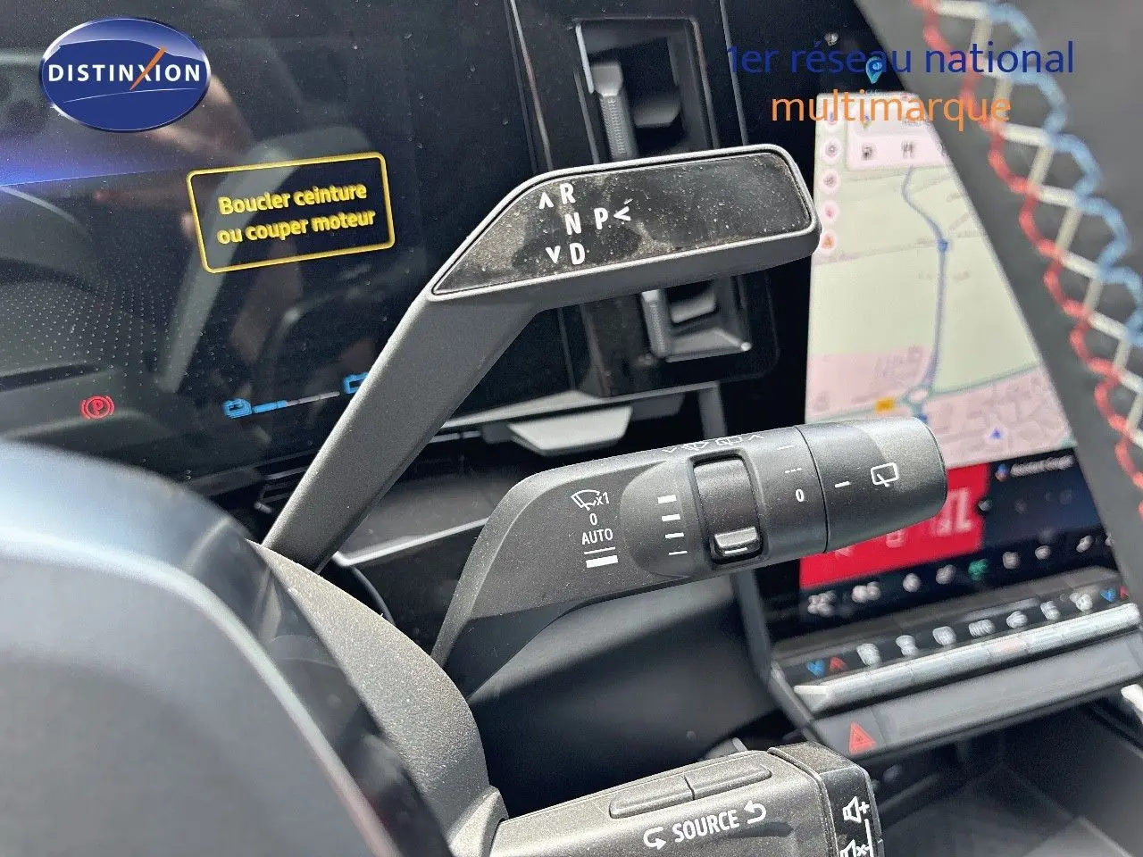 Gros plan sur la commande de boîte automatique et les commandes au volant du Renault Austral bleu Iron Metal, intérieur noir.