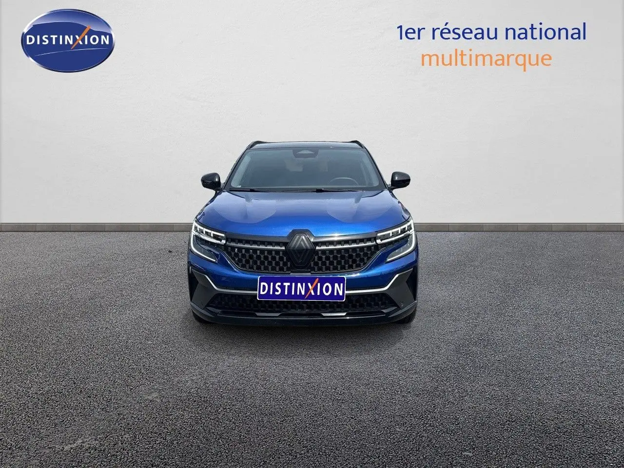 Vue frontale d'un Renault Austral E-Tech hybride bleu Iron Metal avec toit noir, calandre et phares LED distinctifs.