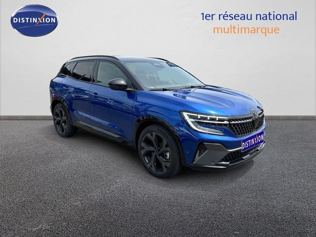 Renault Austral E-Tech hybride bleu Iron Metal avec toit noir, vue 3/4 avant mettant en valeur ses phares LED distinctifs.