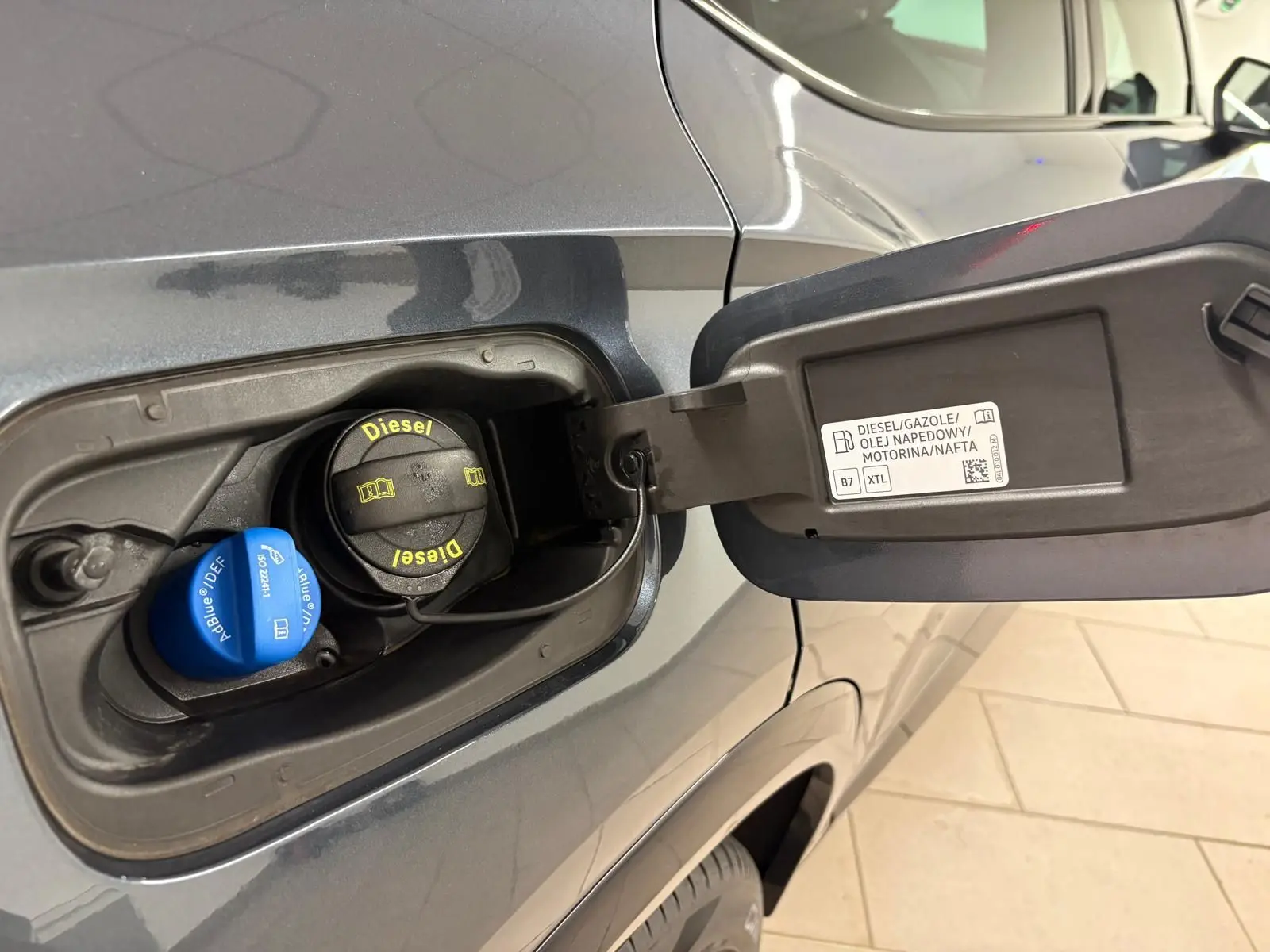Gros plan sur la trappe à carburant côté gauche d'un CUPRA Formentor gris magnétique avec bouchons Diesel et AdBlue visibles.