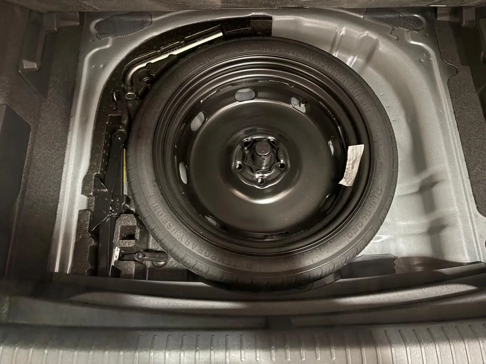 Gros plan sur la roue de secours compacte noire dans le coffre du CUPRA Formentor gris magnétique 2025