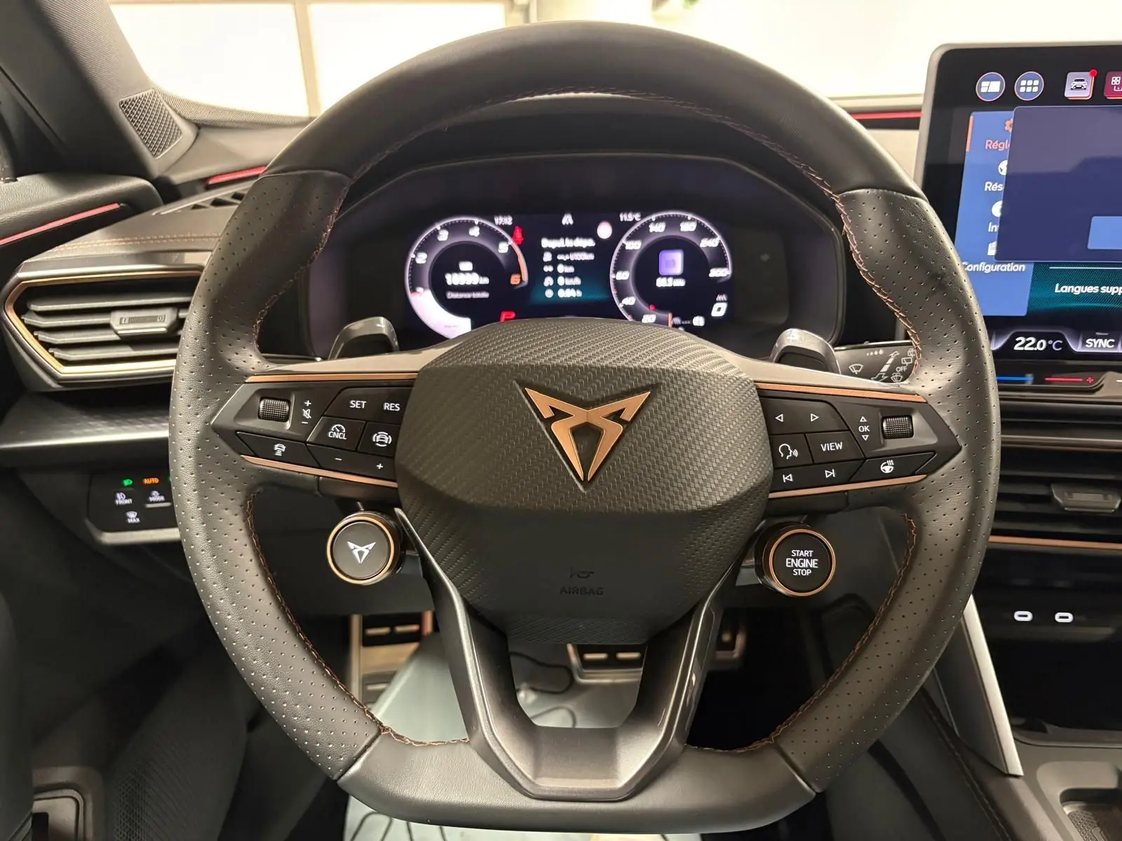 Vue rapprochée du volant perforé noir avec logo CUPRA cuivré et tableau de bord numérique du Formentor 2025.