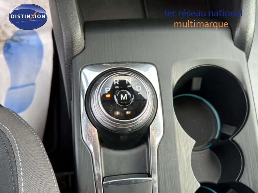 Gros plan sur la molette de sélection de la boîte automatique dans l'habitacle d'une Ford Focus SW noire.