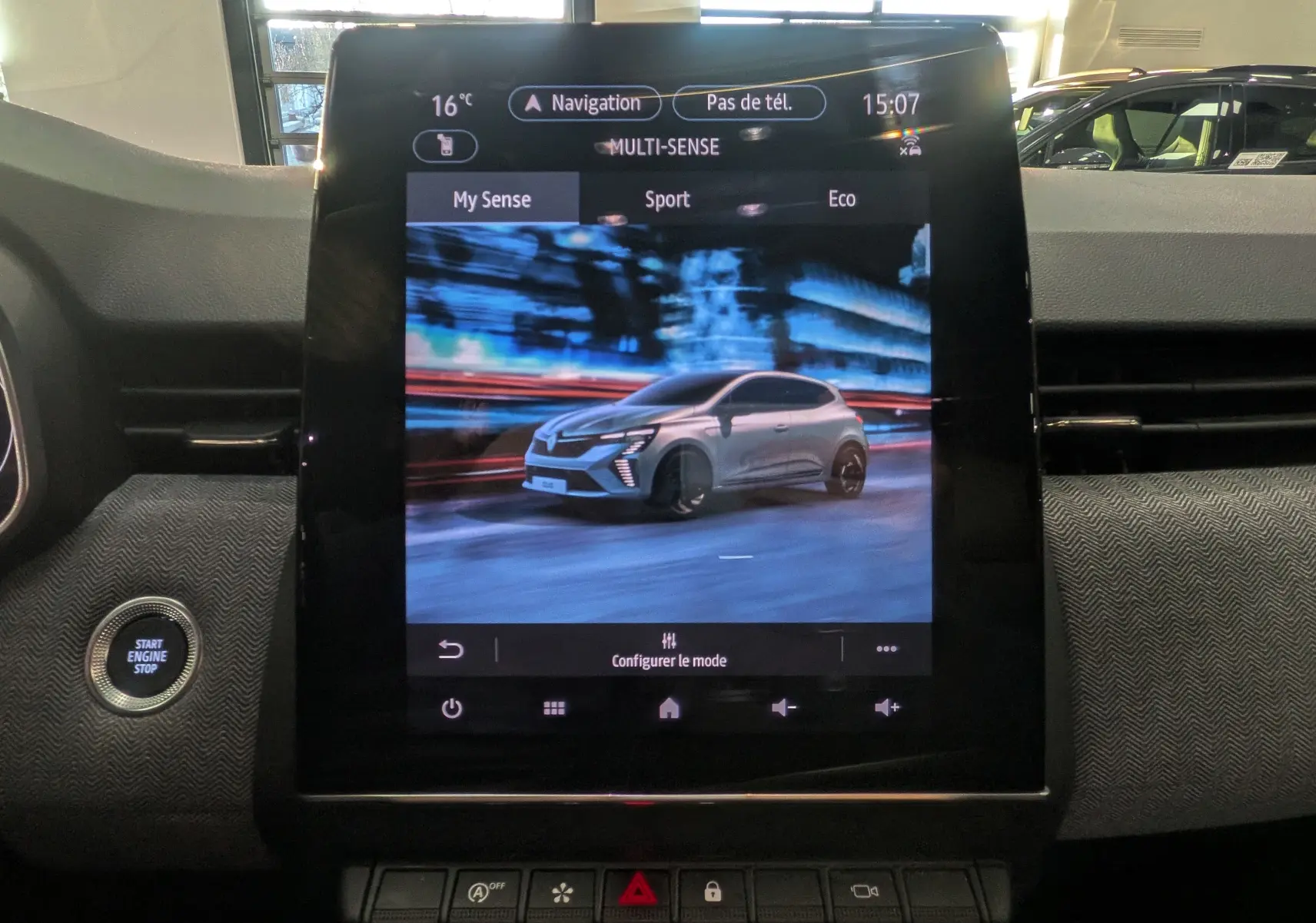 Écran tactile central affichant la Renault Clio V grise en vue 3/4 avant dans l'interface Multi-Sense du tableau de bord.