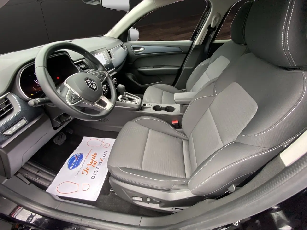 Vue intérieure côté conducteur du Renault Arkana noir 2024, mettant en valeur les sièges et le tableau de bord moderne.