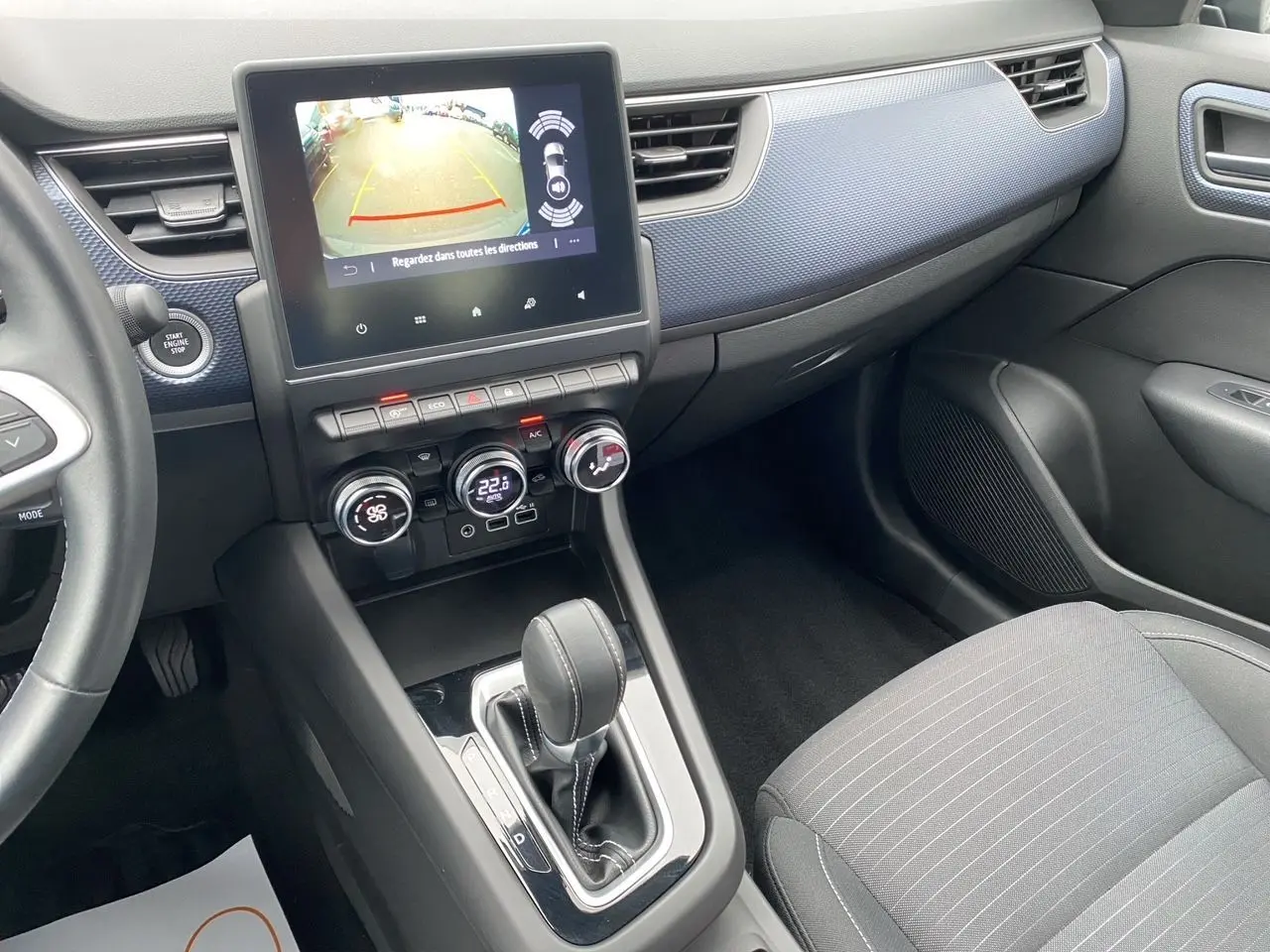 Intérieur du Renault Arkana 2024 noir, vue centrée sur la console centrale avec écran tactile et levier de boîte auto.