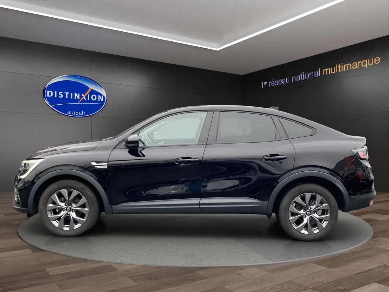 Profil côté gauche du Renault Arkana noir 2024, version TCE 140 EDC Evolution, sur fond intérieur showroom.