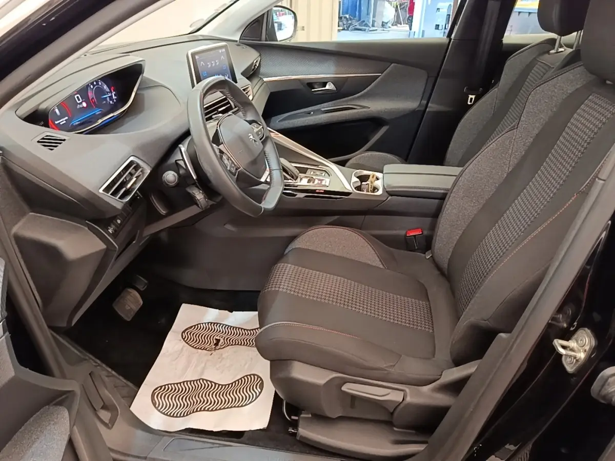 Vue intérieure côté conducteur du Peugeot 3008 noir 2022, montrant le volant cuir multifonctions et l’écran tactile central.