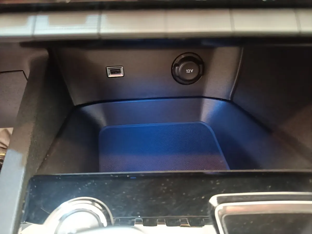 Gros plan sur la console centrale noire du Peugeot 3008 avec prise USB et prise 12V visible.