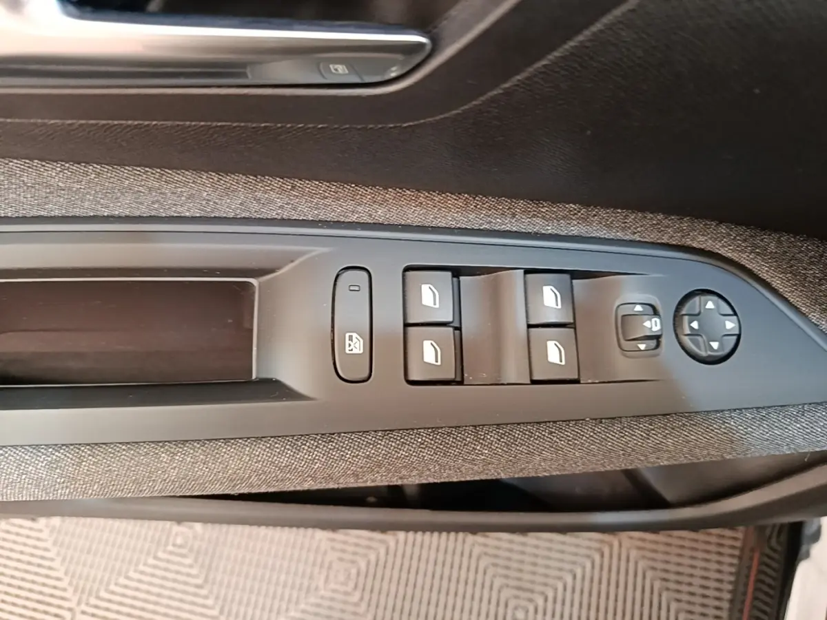 Gros plan sur les commandes des vitres et rétroviseurs côté conducteur du Peugeot 3008 noir, finition Active Pack 2022.