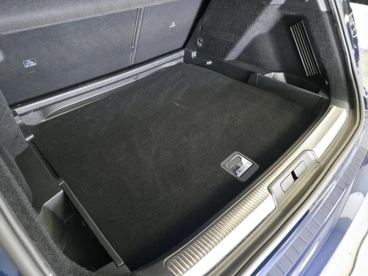 Coffre ouvert vu de dessus du DS7 Crossback bleu, montrant le plancher plat et les finitions intérieures noires.
