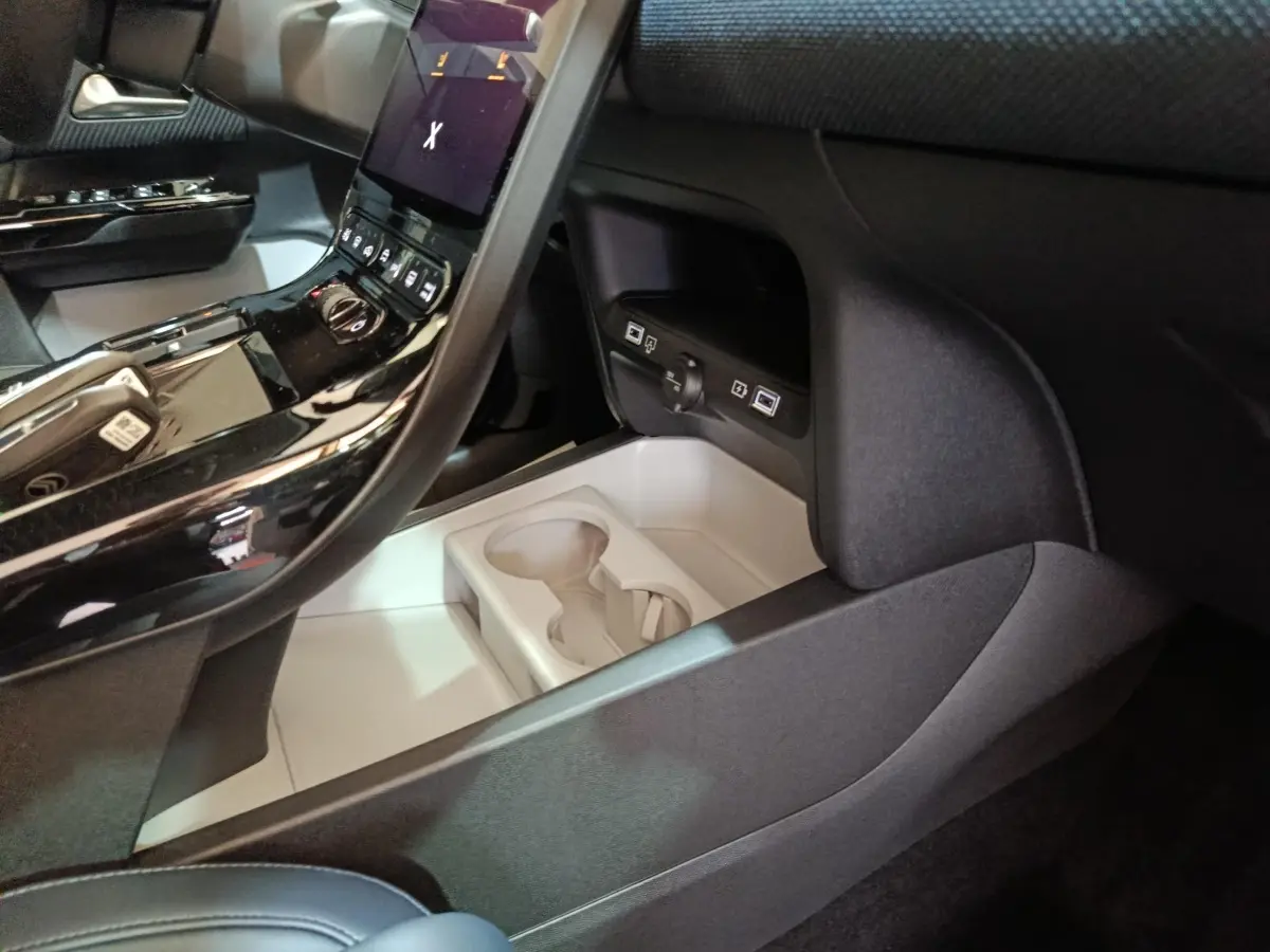 Intérieur noir de la Citroën C5 Hybride 2026, vue console centrale avec écran tactile et porte-gobelets.