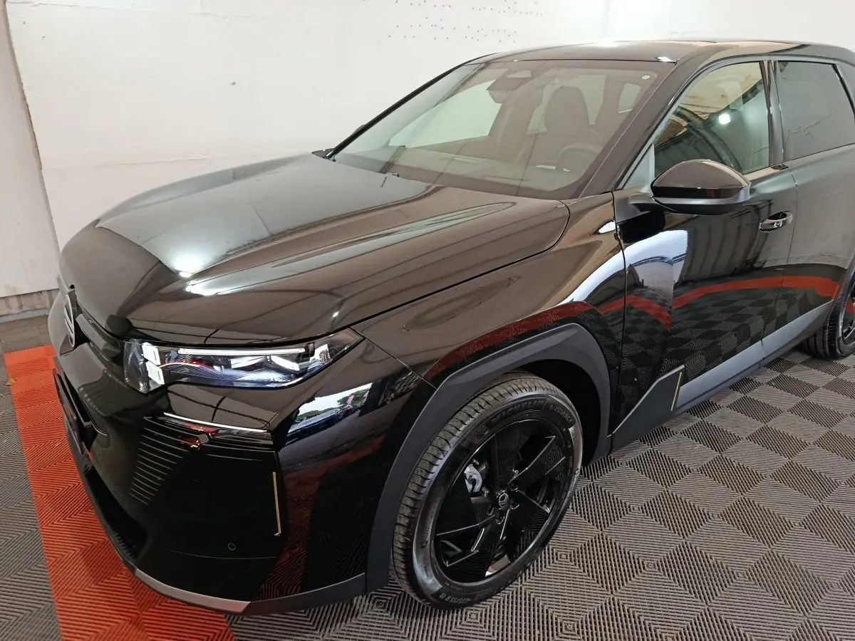 Vue 3/4 avant droite d'une Citroën C5 Hybride noire, soulignant ses phares LED et jantes noires distinctives.