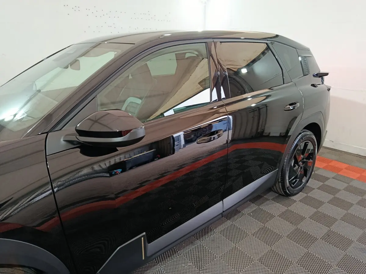 Vue côté gauche d'un Citroën C5 Hybride noir 2026, soulignant la porte et la jante noire brillante.