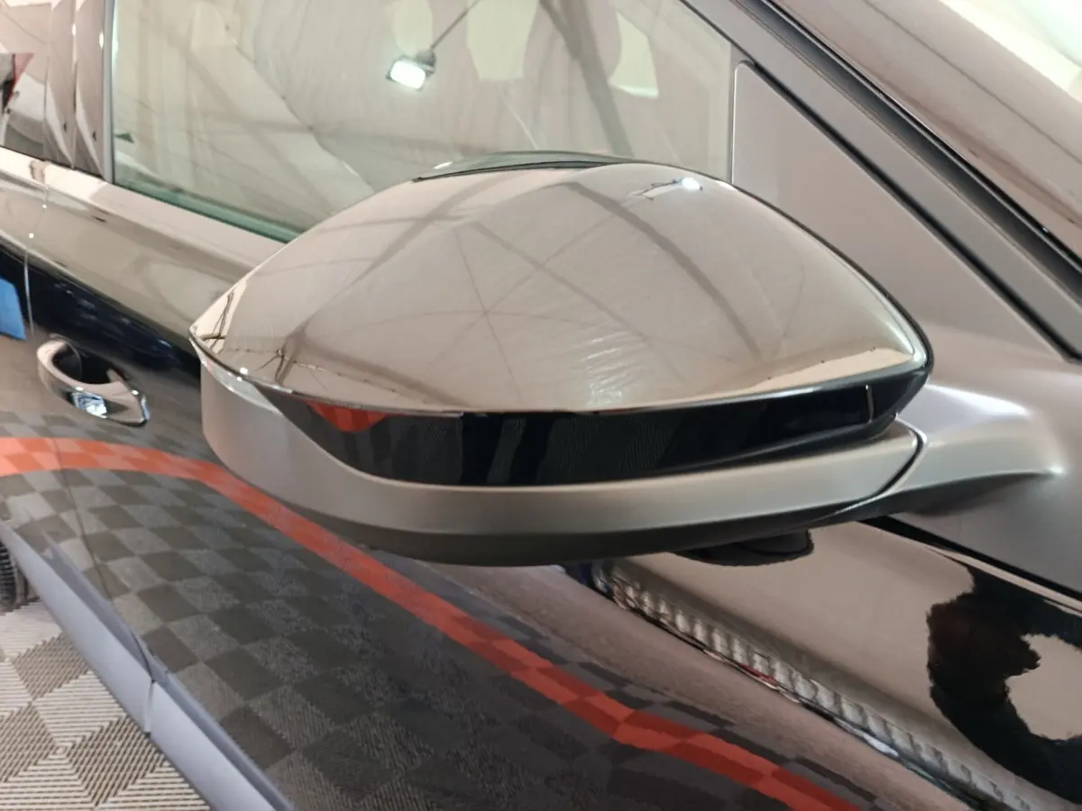 Rétroviseur côté gauche noir brillant de Citroën C5 Hybride 2026 avec surface lisse et reflet intérieur.