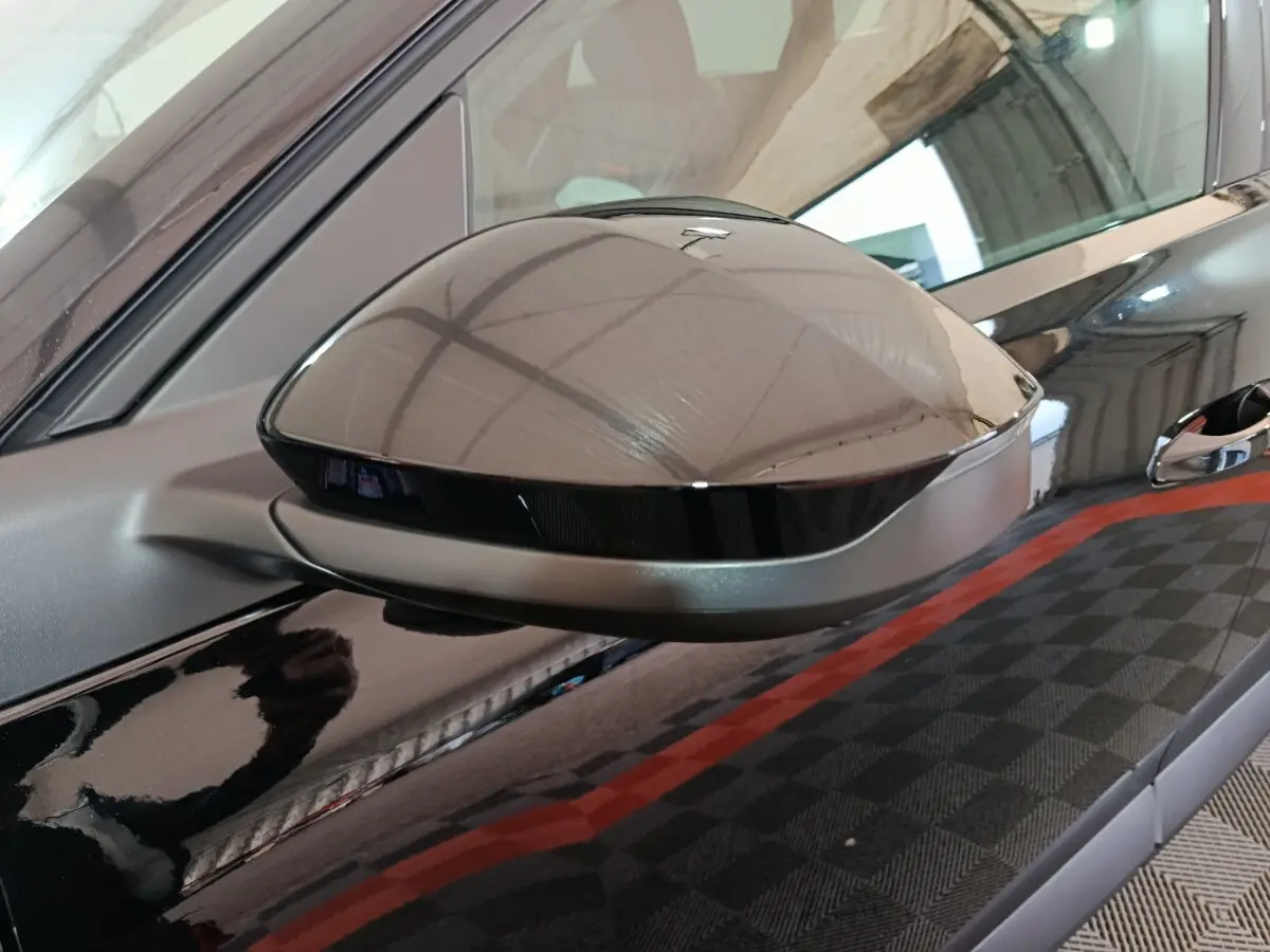 Rétroviseur côté gauche noir brillant de la Citroën C5 Hybride 2026 avec carrosserie noire et poignée visible.