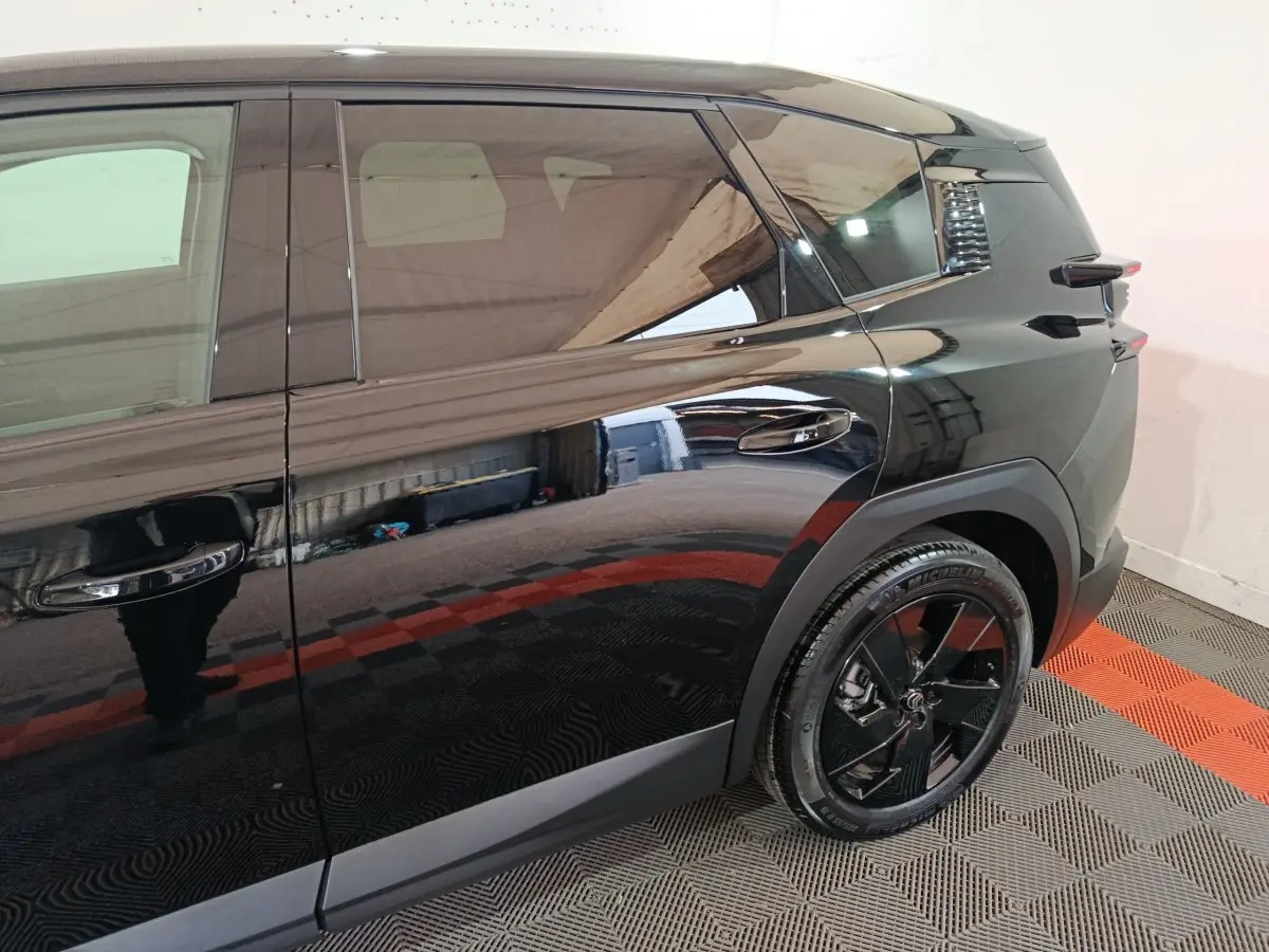 Vue côté droit arrière du Citroën C5 Hybride noir brillant avec jante noire et poignées de porte intégrées.