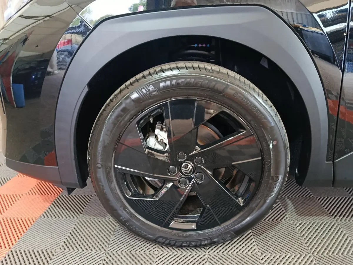 Gros plan sur la roue avant gauche noire d'une Citroën C5 Hybride 2026 avec jante noire brillante et pneu Michelin.