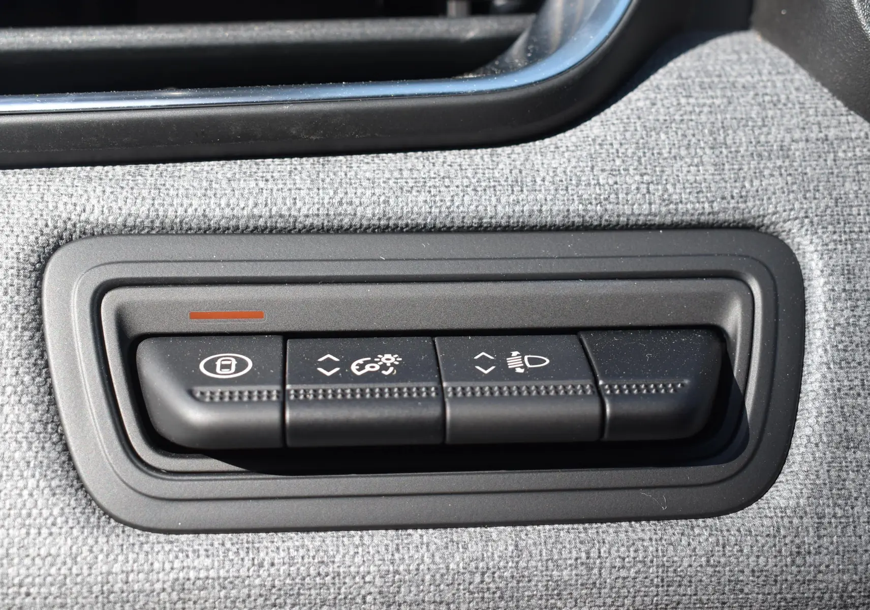 Gros plan sur les commandes de réglage des feux et du tableau de bord dans une Renault Clio V gris 2024.