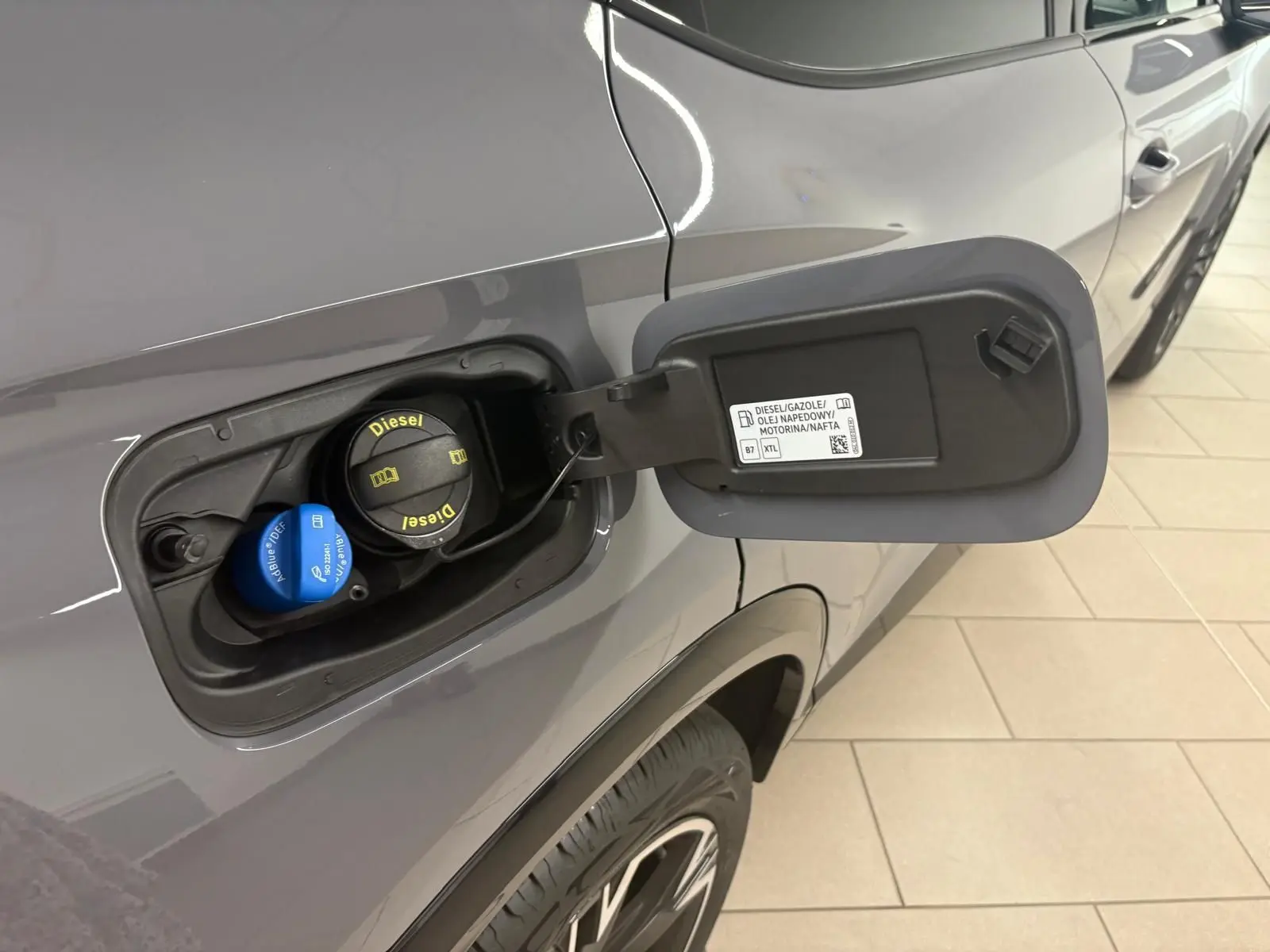 Détail de la trappe à carburant côté gauche d'une CUPRA Formentor gris Graphène 2025 avec bouchon Diesel et AdBlue visible.