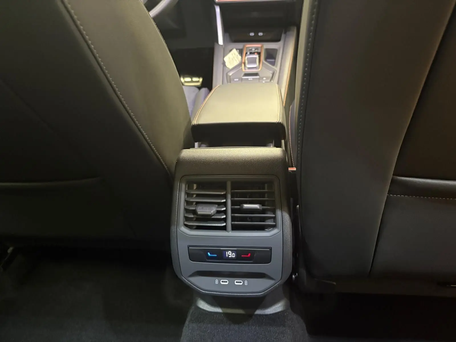 Vue rapprochée de la console arrière entre les sièges avant d'un CUPRA Formentor gris Graphène 2025 avec climatisation réglable.