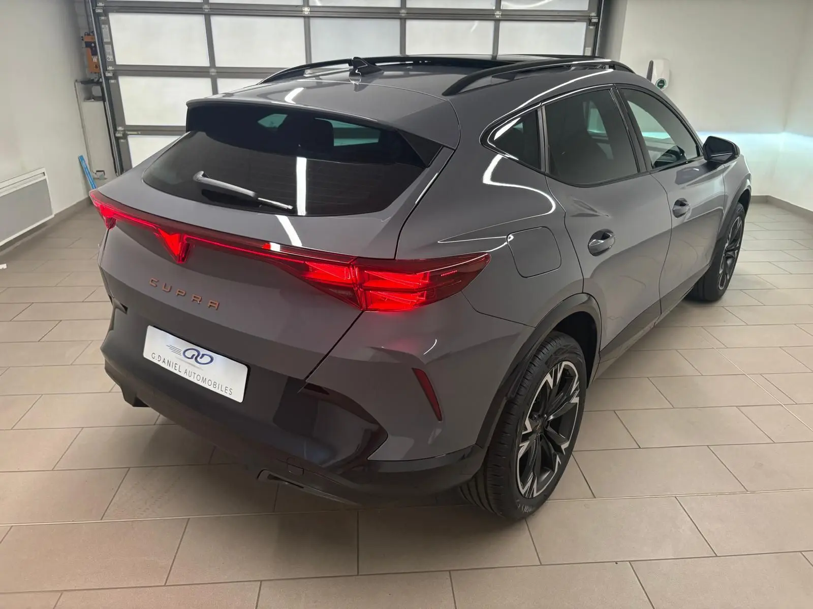 Vue 3/4 arrière droite du CUPRA Formentor 2025 gris Graphène avec toit ouvrant panoramique et jantes alliage 18'' usinées.