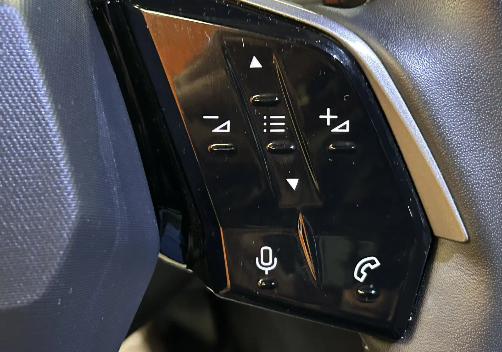 Gros plan sur les commandes vocales et téléphoniques au volant du Peugeot 3008 III Hybrid 145 finition Allure.