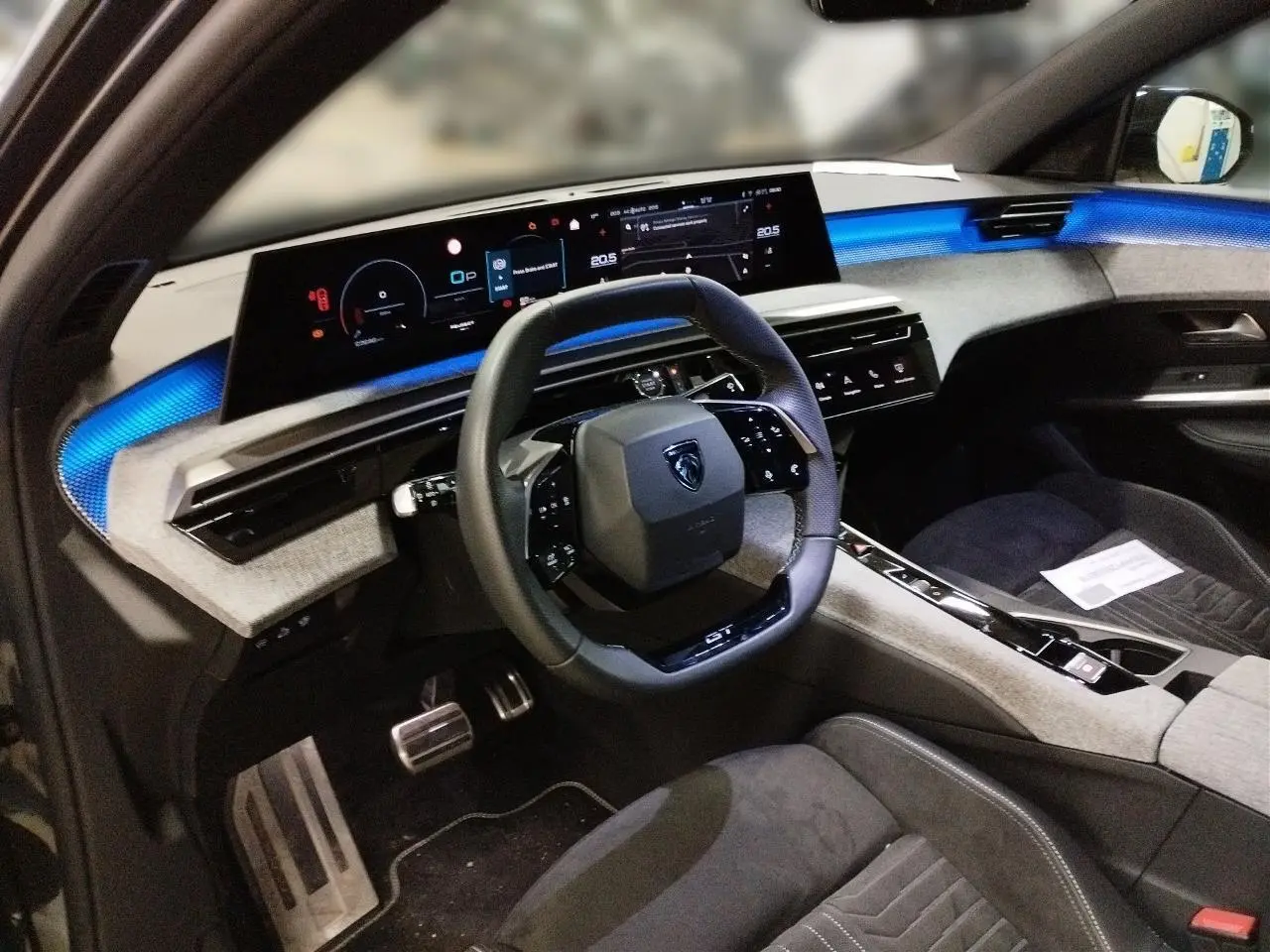 Gros plan sur l'appuie-tête avant en Alcantara gris avec logo Peugeot embossé dans l'habitacle du 3008 Hybrid.