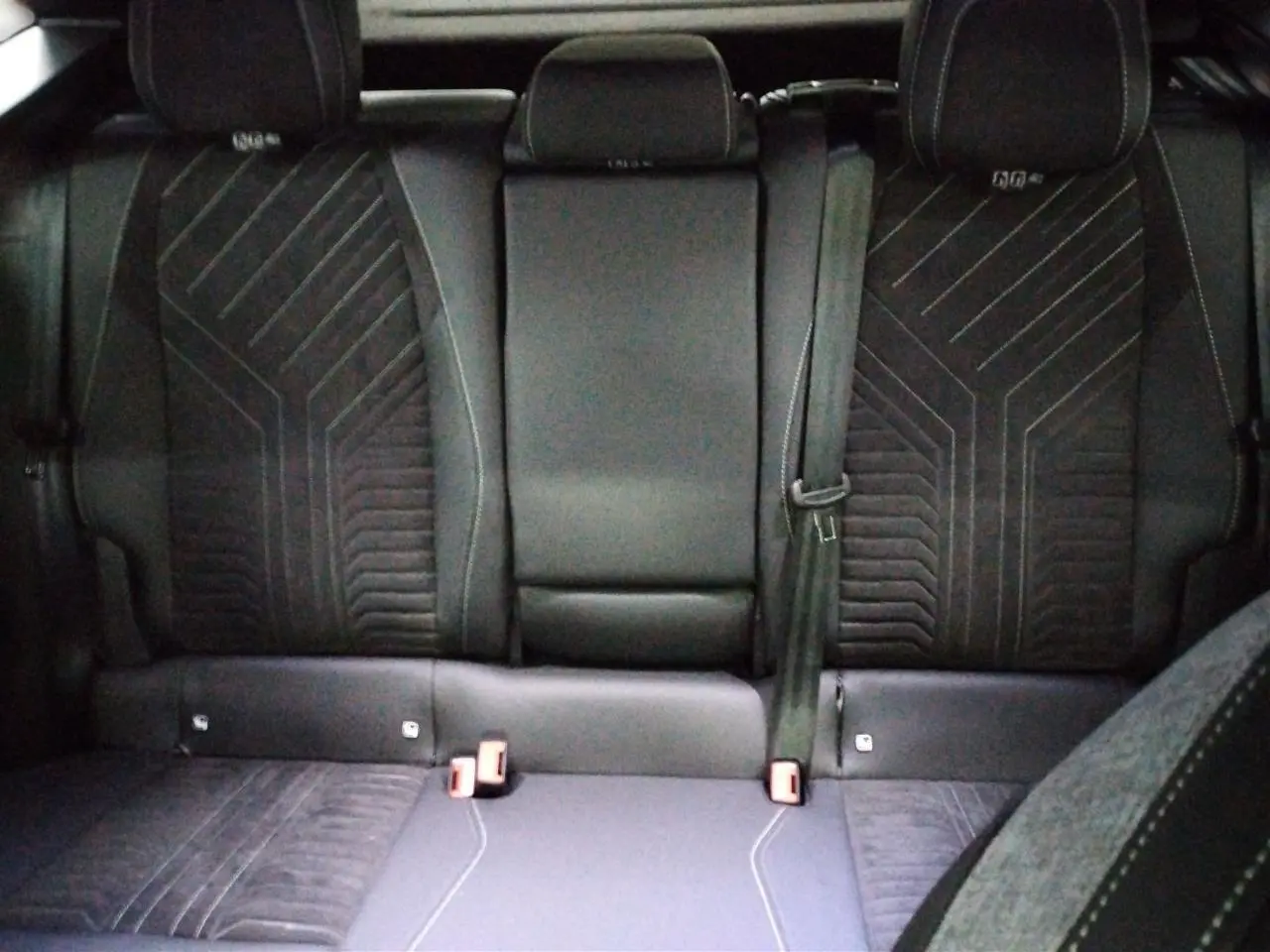 Vue rapprochée des commandes électriques de réglage du siège conducteur sur la porte intérieure noire du Peugeot 3008 Hybrid 2025.