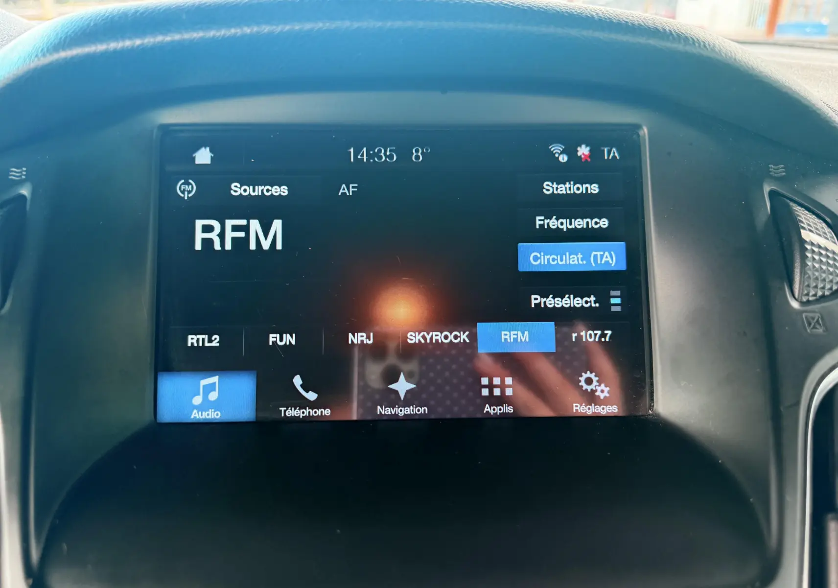 Vue intérieure côté conducteur de la Ford Focus 1.5 TDCI gris, avec sièges tissu noir et volant multifonction.