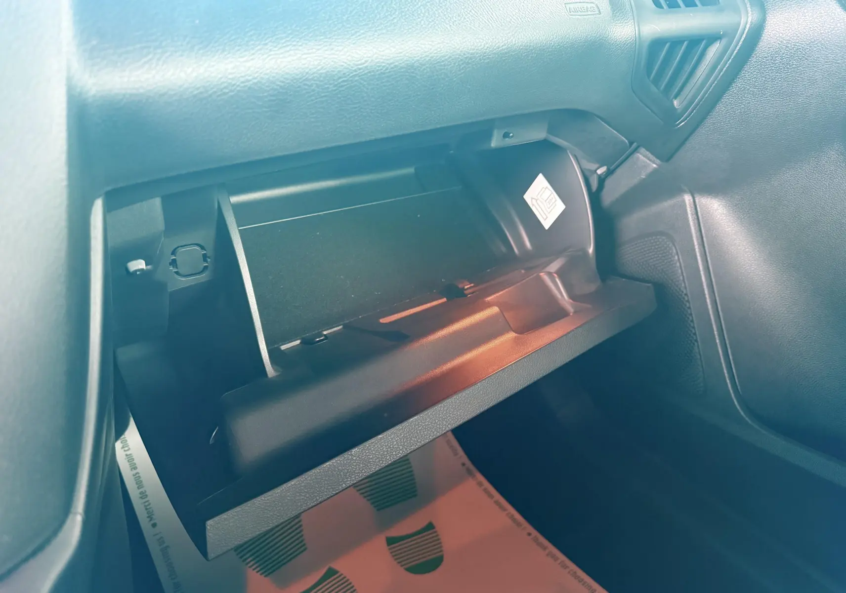 Gros plan sur les commandes multifonctions noires du volant en cuir perforé d'une Ford Focus gris 2018, version ST Line.