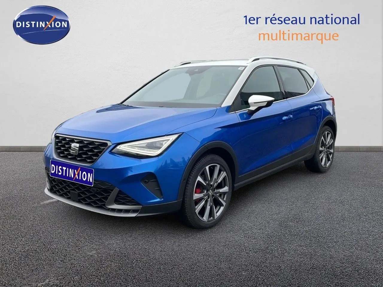 SEAT Arona bleu saphir métal avec toit blanc, vue 3/4 avant droit, jantes alliage et calandre distinctive.