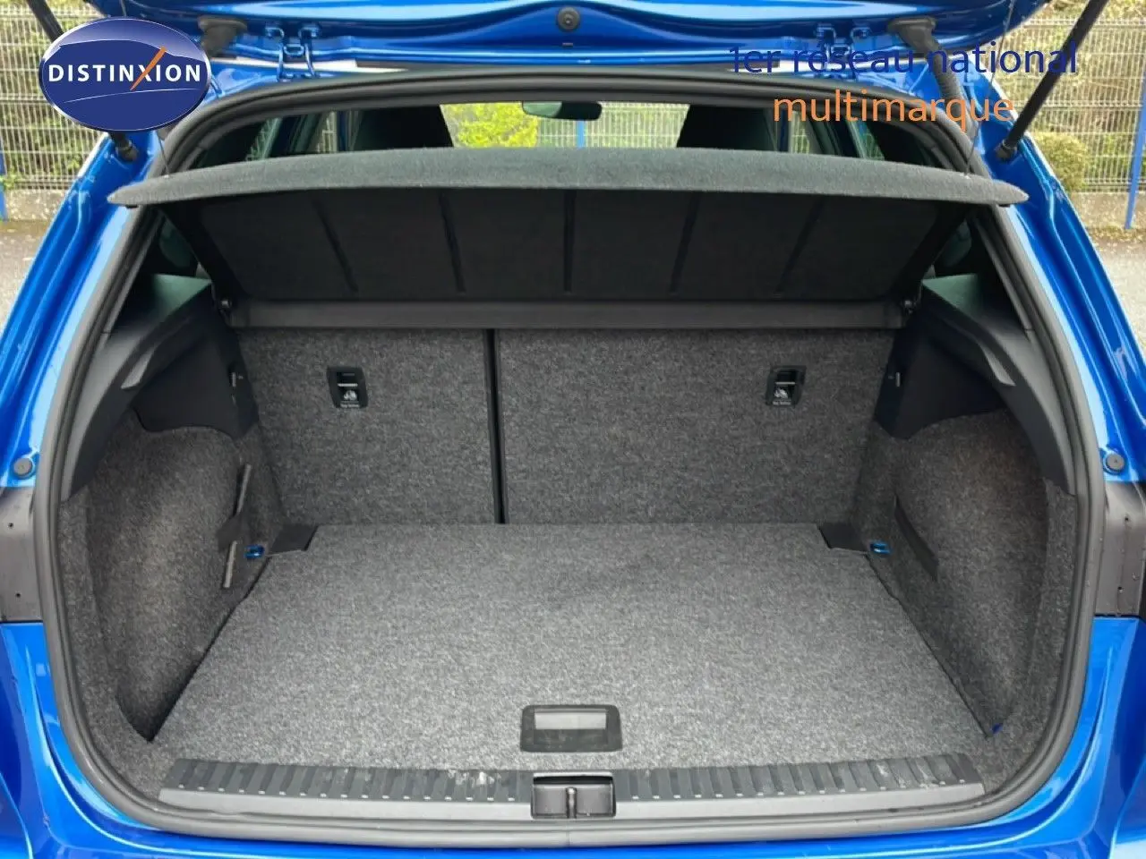 Vue arrière ouverte du coffre spacieux d'un SEAT Arona 2025 bleu saphir métal avec intérieur gris.