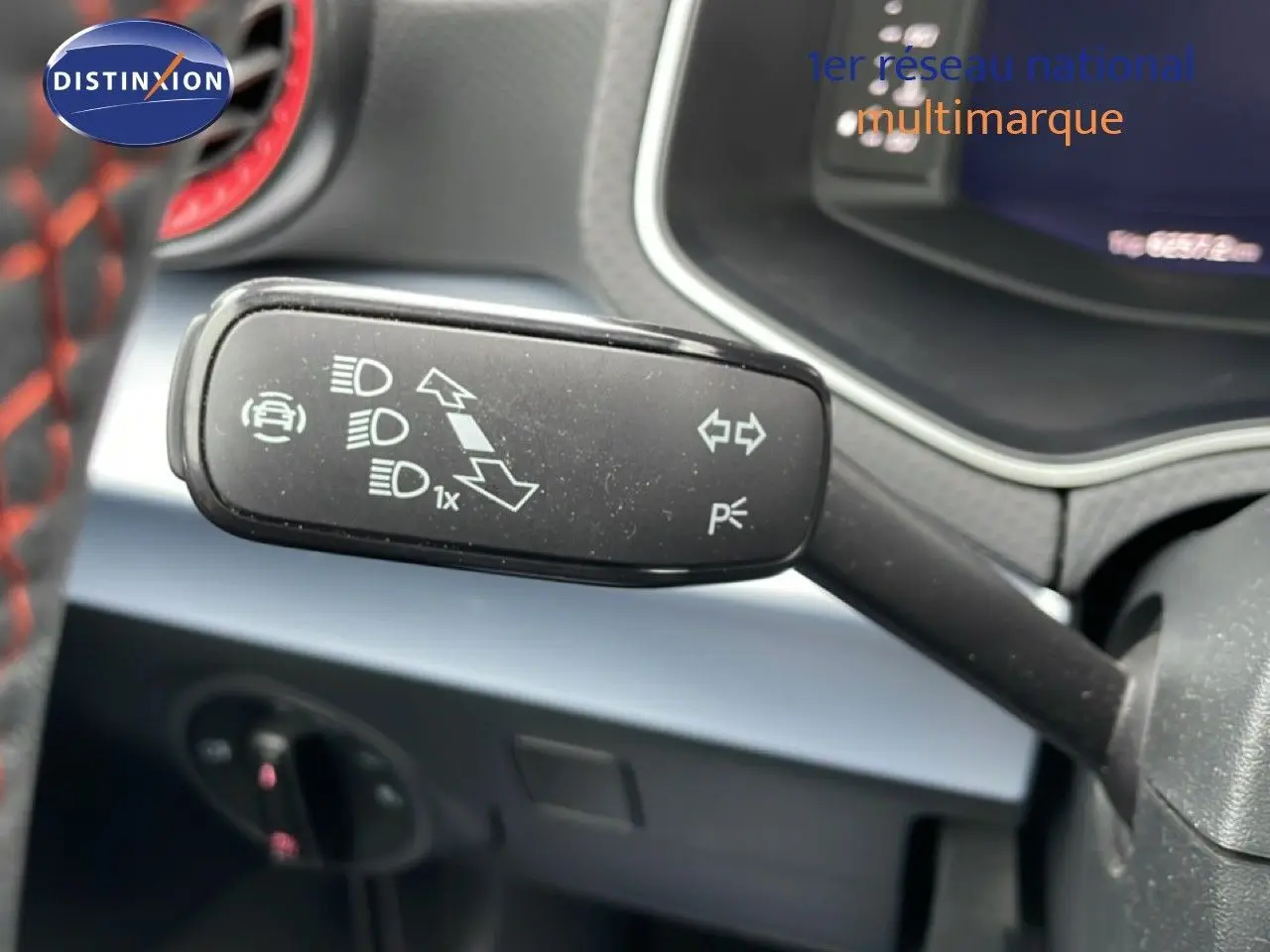 Gros plan sur la commande de clignotants dans l’habitacle d’un SEAT Arona bleu saphir métal avec toit blanc.