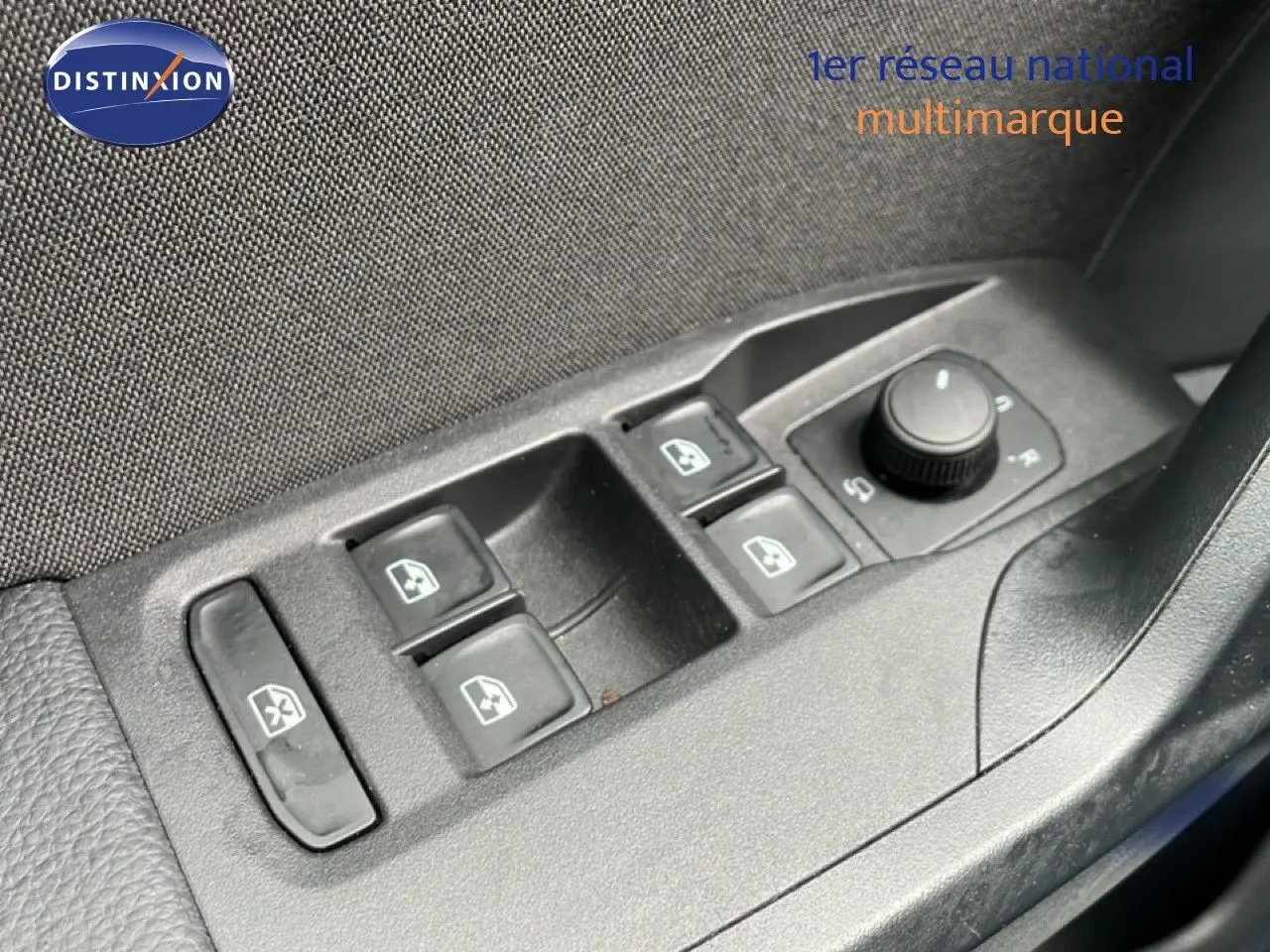 Vue rapprochée des commandes de lève-vitres et rétroviseurs côté conducteur d'un SEAT Arona bleu saphir métal avec toit blanc.