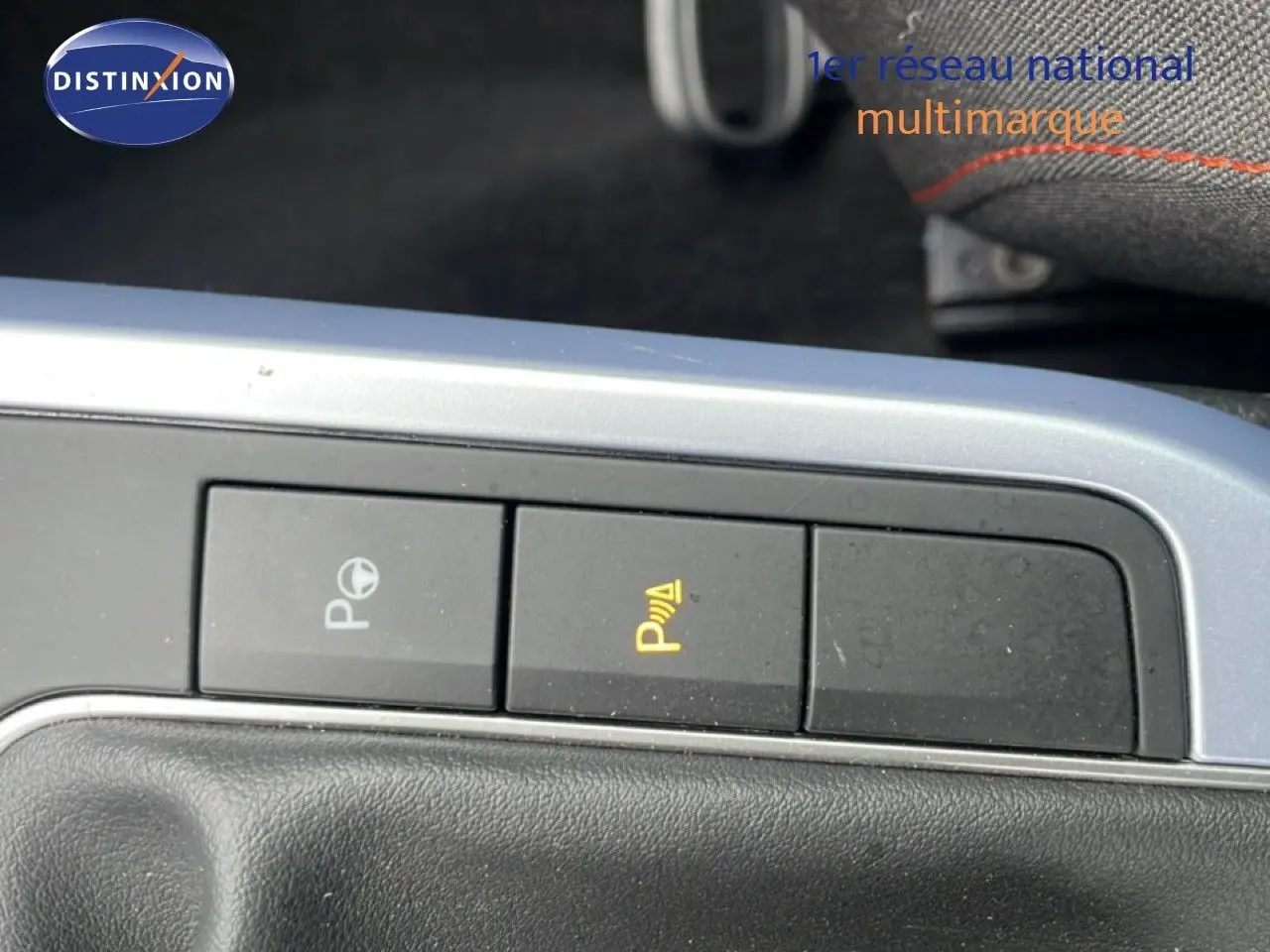 Gros plan sur les boutons de commande du système d'aide au stationnement dans l'habitacle du SEAT Arona 2025.